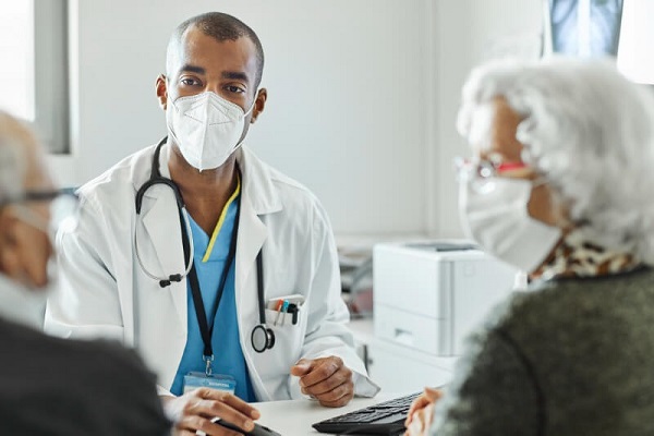 doctor in a mask talking with patients